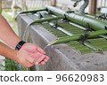 Men's hands purifying their hands at the chozuya 96620983