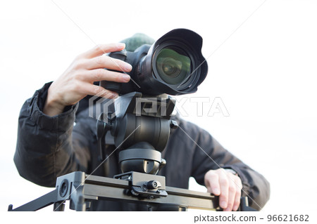 A man shooting a video using a slider A man shooting a video using a slider 96621682