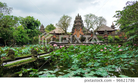 The recognizable architecture of Balinese temples. The entrance gate to the temple is through a garden with a pond and lilies 96621786