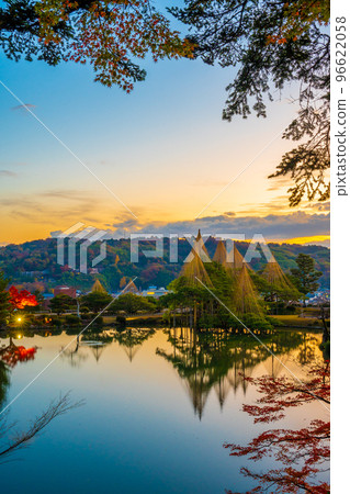 An early morning landscape where the winter tradition of snow hanging and the morning glow are beautifully reflected on Kenrokuen's Kasumigaike Pond｜Kanazawa City, Ishikawa Prefecture 96622058