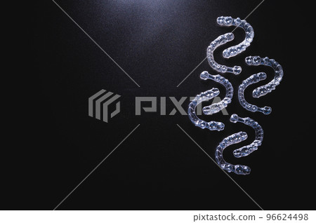 pattern of transparent plastic braces on a black background with free space for advertising 96624498
