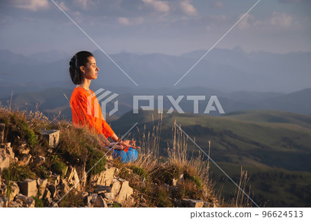 meditating woman with closed eyes in bright clothes in the mountains, sportswear advertising banner meditating woman with closed eyes in bright clothes in the mountains, sportswear advertising banner 96624513
