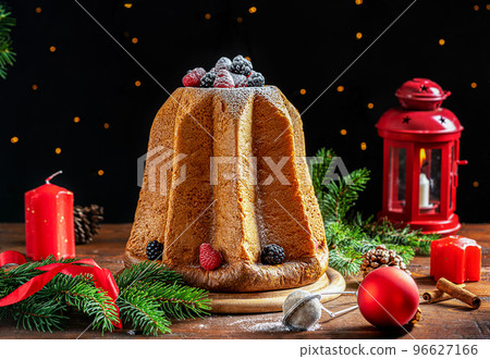 Traditional Italian Christmas cake Pandoro on wooden table with Christmas decoration, lights on dark background Traditional Italian Christmas cake Pandoro on wooden table with Christmas decoration, lights on dark background 96627166