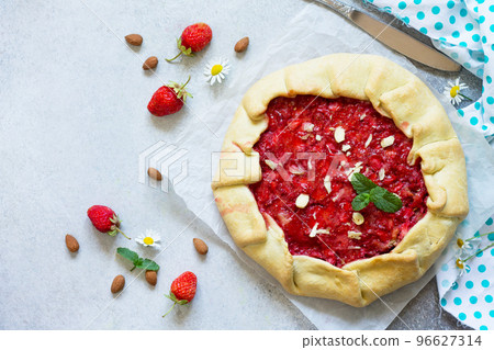 Fresh homemade strawberries galette with nut cream on a gray stone or slate background. Top view flat lay background. Copy space. Fresh homemade strawberries galette with nut cream on a gray stone or slate background. Top view flat lay background. Copy space. 96627314