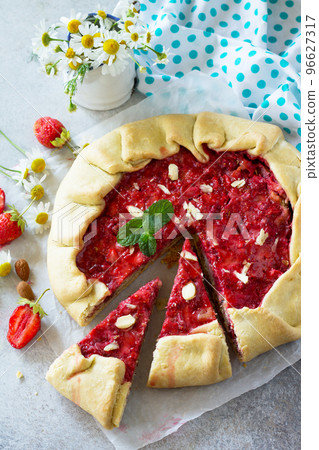 Fresh homemade strawberries galette with nut cream on a gray stone or slate background. Copy space. 96627317