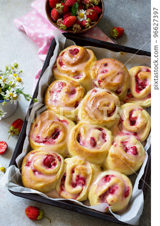 Fresh Homemade Rolls Buns with strawberry with Cream Cheese in glaze for Breakfast on a stone or slate gray background. Fresh Homemade Rolls Buns with strawberry with Cream Cheese in glaze for Breakfast on a stone or slate gray background. 96627397