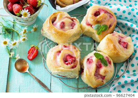 Fresh Homemade Rolls Buns with strawberry with Cream Cheese in glaze for Breakfast on kitchen table. Copy space. 96627404