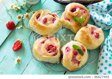 Fresh Homemade Rolls Buns with strawberry with Cream Cheese in glaze for Breakfast on kitchen table. 96627405