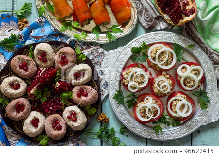 Georgian cuisine. Fresh homemade Rolls of peppers stuffed with nuts, tomatoes and walnut coriander sauce, pkhali bean. Top view flat lay background. 96627415