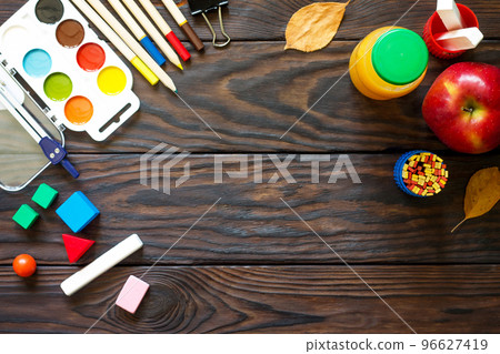 Back to school background with school supplies, autumn leaves and apple on a wooden table, copy space. Back to school background with school supplies, autumn leaves and apple on a wooden table, copy space. 96627419
