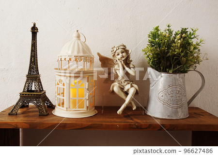Eiffel tower, white lantern, ceramic doll and artificial plant on wooden shelf Interior home decoration Eiffel tower, white lantern, ceramic doll and artificial plant on wooden shelf Interior home decoration 96627486