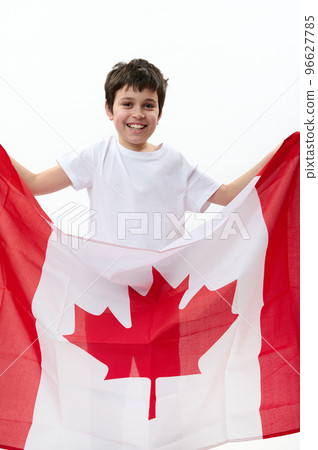 American teenage boy carries Canadian flag, celebrates Independence Day of Canada, July 1, isolated over white background, with advertising space for text. Citizenships Patriotism Emigration Concept American teenage boy carries Canadian flag, celebrates Independence Day of Canada, July 1, isolated over white background, with advertising space for text. Citizenships Patriotism Emigration Concept 96627785