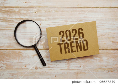 Trend 2026 text message and magnifying glass with space copy on wooden background 96627819