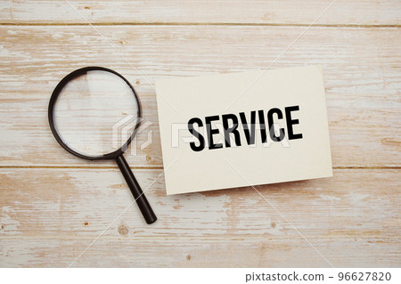 Service text message and magnifying glass with space copy on wooden background 96627820