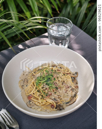 Pasta Bucatini Carbonara and coconut on the table. Pasta Bucatini Carbonara and coconut on the table. 96629621