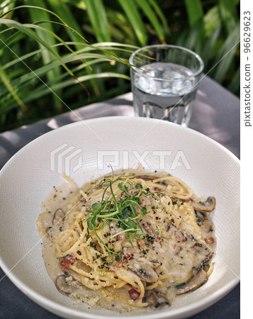 Pasta Bucatini Carbonara and coconut on the table. Pasta Bucatini Carbonara and coconut on the table. 96629623