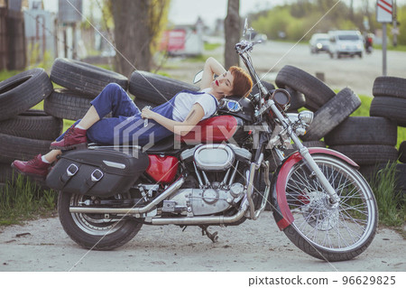 Girl auto mechanic lies on a motorcycle Girl auto mechanic lies on a motorcycle 96629825