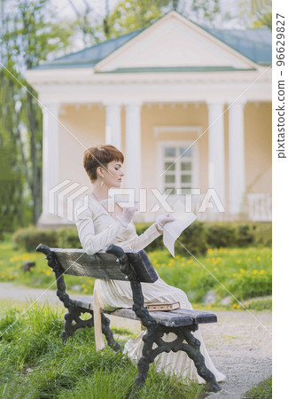 beautiful woman in golden dress writes a letter with a quill pen beautiful woman in golden dress writes a letter with a quill pen 96629827