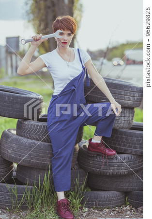 attractive woman mechanic in overalls holding wrench attractive woman mechanic in overalls holding wrench 96629828