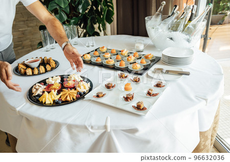 A wide variety of snacks on the table for guests. Shrimp, boiled pork, various types of meat and other products A wide variety of snacks on the table for guests. Shrimp, boiled pork, various types of meat and other products 96632036