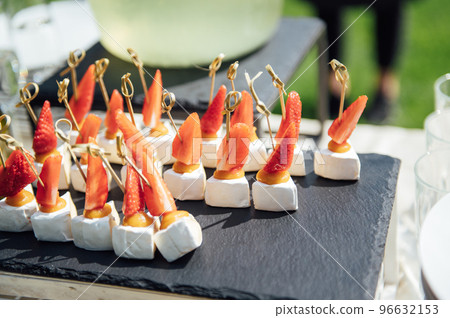 Sandwiches, canapes and cakes on the festive table. A wide variety of snacks Sandwiches, canapes and cakes on the festive table. A wide variety of snacks 96632153
