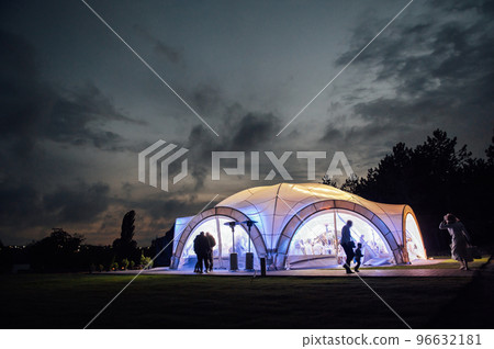 Large wedding tent in the open area for receiving guests. Evening photo with a beautiful sunset 96632181