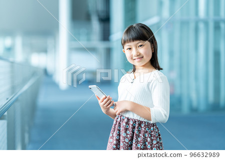 Elementary school girl using a smartphone 96632989