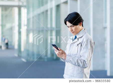 Young male engineer using smartphone 96633580