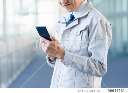 Young male engineer using smartphone 96633581