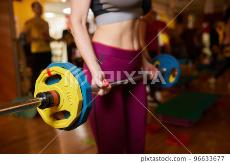 group of young sport people training with barbell at a gym for better fitness. group of young sport people training with barbell at a gym for better fitness. 96633677