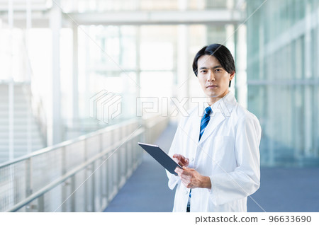 Young male doctor checking chart on tablet Young male doctor checking chart on tablet 96633690