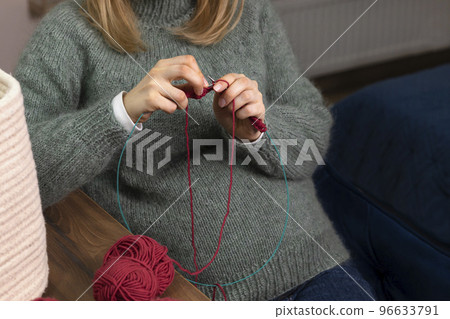 Unrecognized pregnant women knits sitting in chair, wears warm clothes,sweater in cold season. Hobby 96633791
