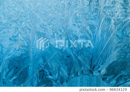 Frosty patterns on glass. Christmas background. Blue ice on winter window. Frosty patterns on glass. Christmas background. Blue ice on winter window. 96634129