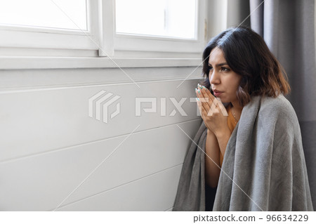 Energy Crisis. Freezing Arab Woman Sitting Near Cold Radiator At Home Energy Crisis. Freezing Arab Woman Sitting Near Cold Radiator At Home 96634229