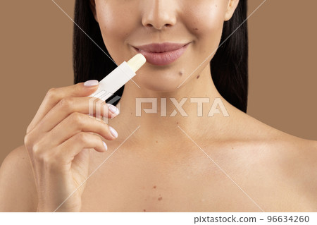 Cropped of woman applying lip balm on beautiful soft lips 96634260