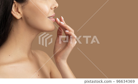Unrecognizable topless woman using balm for lips 96634369