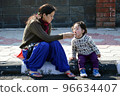 Mother and daughter eating ice cream outdoors 96634407