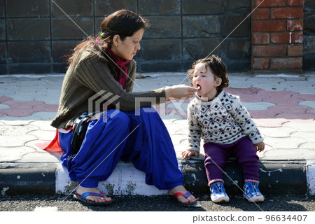 Mother and daughter eating ice cream outdoors 96634407
