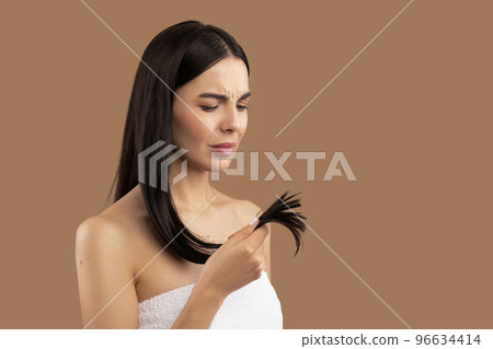 Unhappy woman holding her hair split ends in hand 96634414
