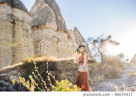 Woman tourist on background of Unique geological formations in Love Valley in Cappadocia, popular travel destination in Turkey Woman tourist on background of Unique geological formations in Love Valley in Cappadocia, popular travel destination in Turkey 96634817