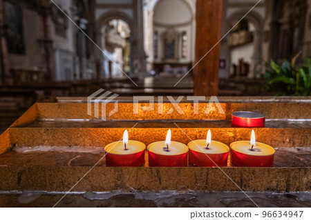 Candles with flame inside of a church 96634947