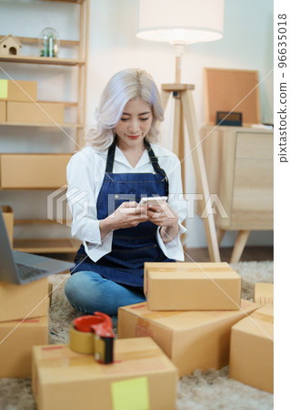 Starting small business entrepreneur of independent Asian woman smiling using computer laptop with cheerful success of online marketing package box items and SME delivery concept. 96635018