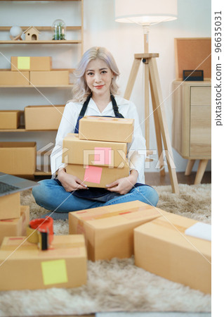 Starting small business entrepreneur of independent Asian woman smiling using computer laptop with cheerful success of online marketing package box items and SME delivery concept. 96635031