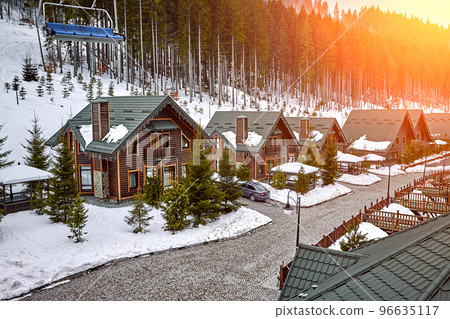 Winter vacation holiday wooden house in the mountains covered with snow and blue sky. Sun flare Winter vacation holiday wooden house in the mountains covered with snow and blue sky. Sun flare 96635117