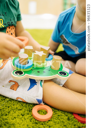 Little children play with wooden toys in kindergarden Little children play with wooden toys in kindergarden 96635323
