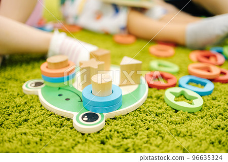 Little children play with wooden toys in kindergarden Little children play with wooden toys in kindergarden 96635324