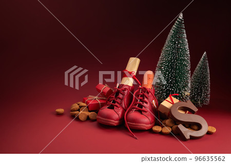 Saint Nicholas - Sinterklaas day with shoe, carrot and traditional sweets on red background 96635562