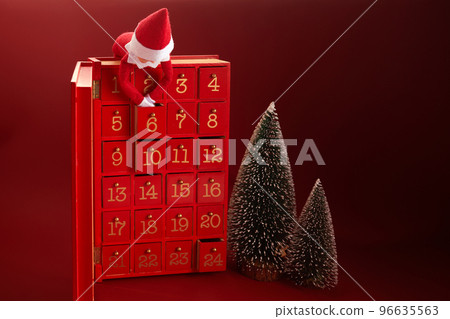Christmas advent calendar with an elf and gifts on red background Christmas advent calendar with an elf and gifts on red background 96635563