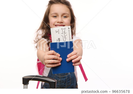Selective focus on boarding pass or flight ticket in the hands of blurred cutely smiling baby girl, isolated over white background with free space for advertising text. Travel by air. Journey. Tourism Selective focus on boarding pass or flight ticket in the hands of blurred cutely smiling baby girl, isolated over white background with free space for advertising text. Travel by air. Journey. Tourism 96635678