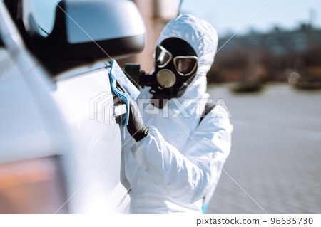 Hand of Man in protective suit washing and disinfection handles of a car.Pandemic in quarantine city Hand of Man in protective suit washing and disinfection handles of a car.Pandemic in quarantine city 96635730
